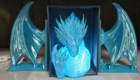 Blue dragon-shaped object on a white surface with a dark background